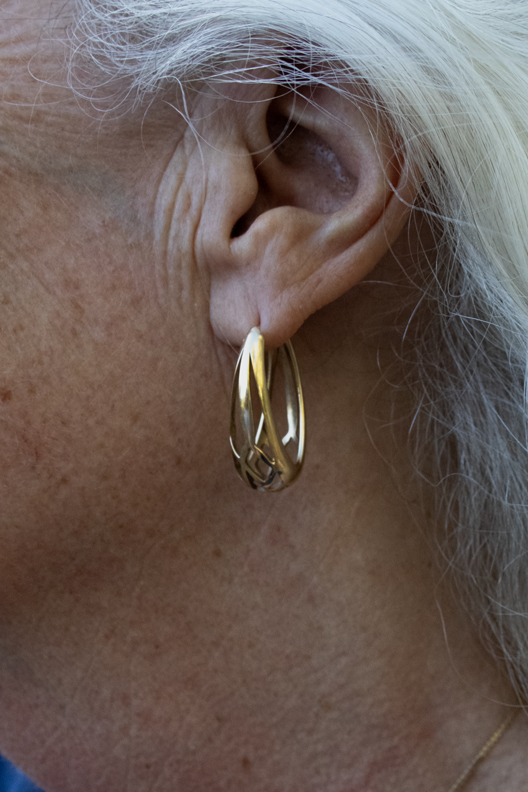 Model wears Cicada Hoops in 14k yellow gold by Kestrel Dillon Model wears Cicada Hoops in 14k yellow gold by Kestrel Dillon