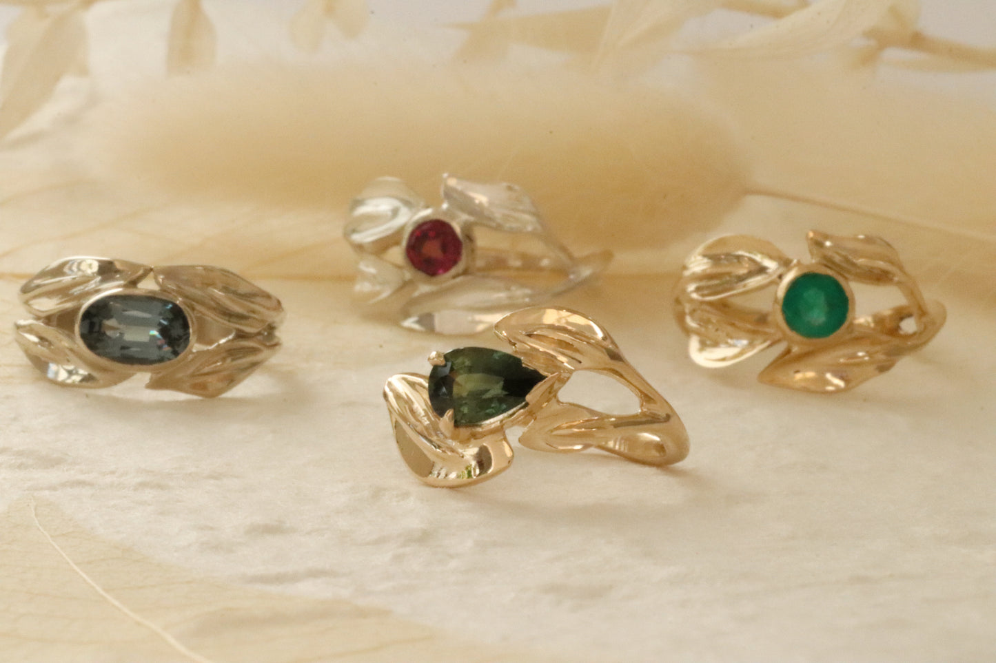 Group lifestyle shot of East / West Willow Ring, Garnet Willow Ring, Curved Willow Ring, and Emerald Willow Ring by Kestrel Dillon Group lifestyle shot of East / West Willow Ring, Garnet Willow Ring, Curved Willow Ring, and Emerald Willow Ring by Kestrel Dillon