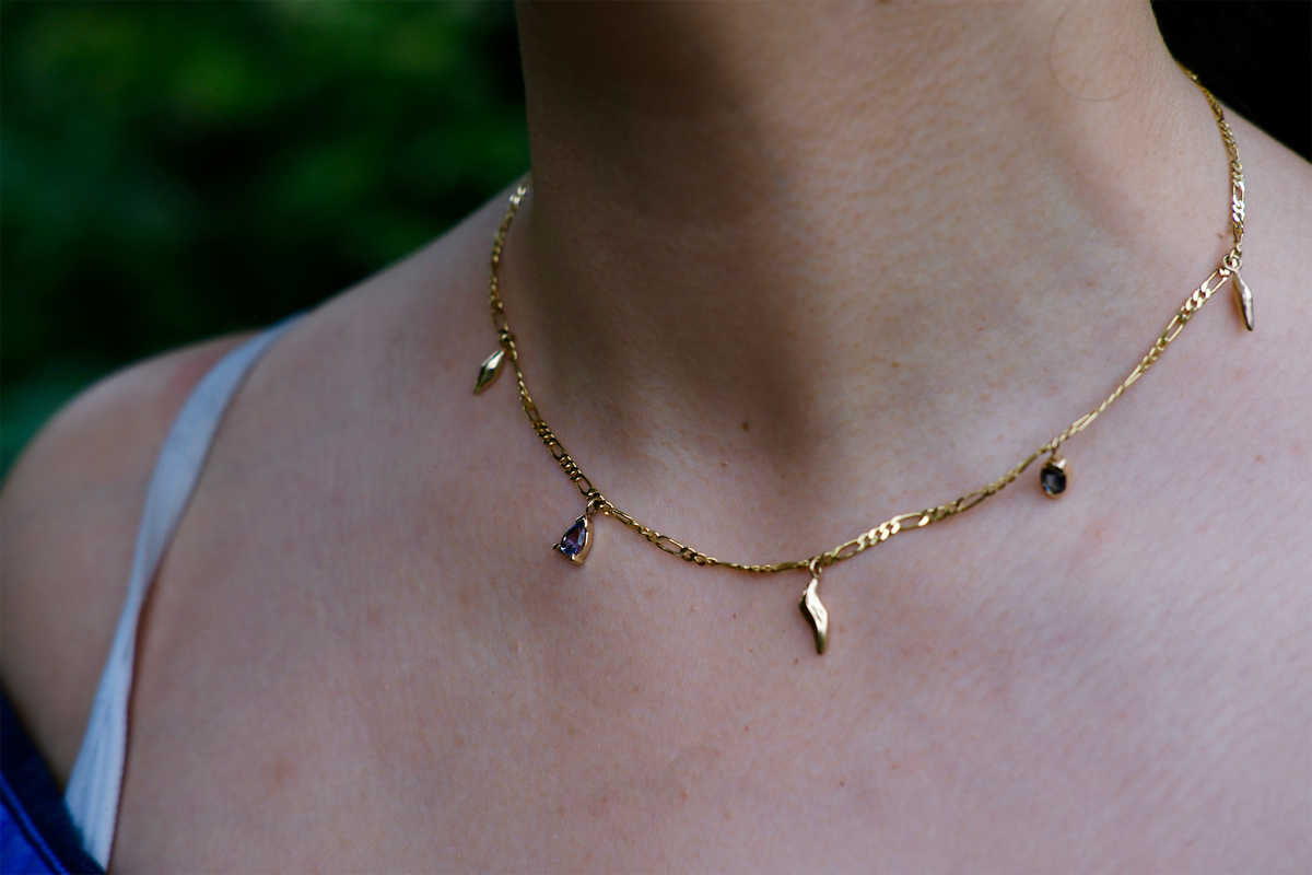 Model wears Wren Gemstone Necklace with blurred backdrop